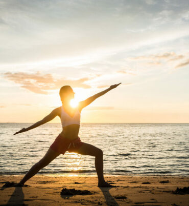 Silhouette of a fit woman practicing the warrior yoga pose again